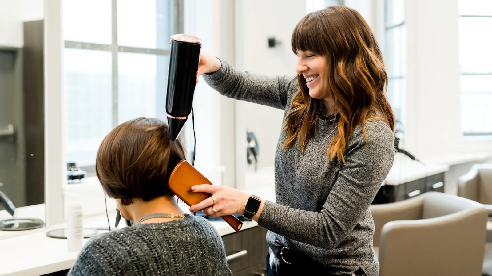 Coiffeur professionnel coupant les cheveux d'une cliente dans un salon