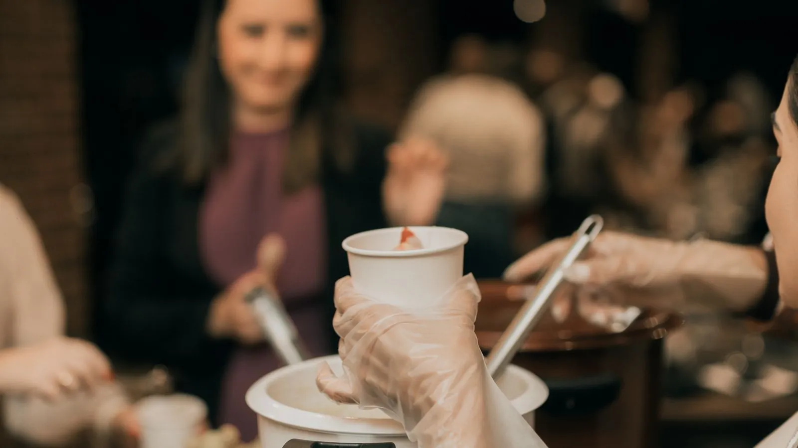Traiteur dressant un buffet raffiné de canapés et verrines sur une table d'événement