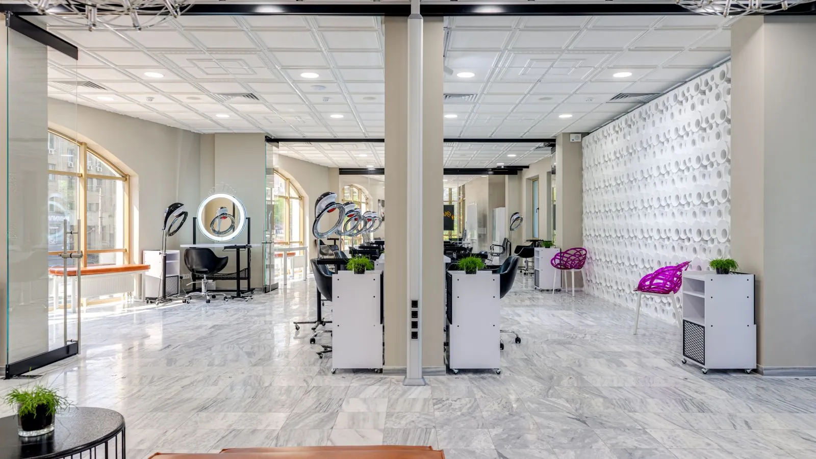 Salon de coiffure moderne avec fauteuils vides en milieu de semaine, lumière naturelle douce